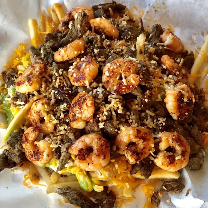 Roberto's Taco Shop's carne asada and shrimp fries, topped with cheese and avocado.