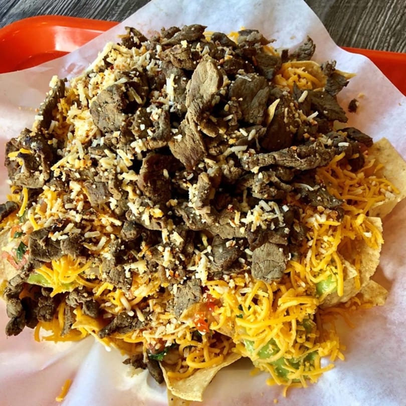Roberto's Taco Shop carne asada nachos with shredded cheese, avocado, and pico de gallo.